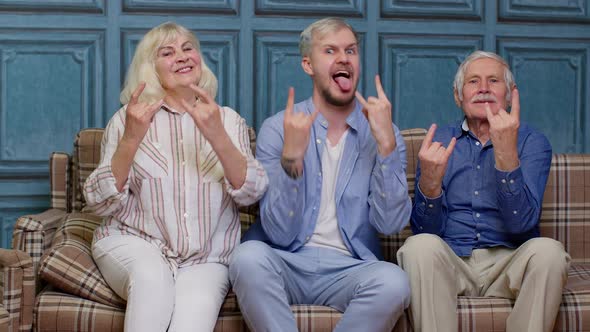 Happy Generation Family of Senior Grandparents with Adult Son Listening to Music Dancing at Home