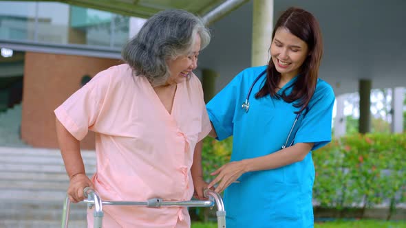 Asian careful caregiver or nurse taking care of the elderly Asian patient in a wheelchair. Concept o