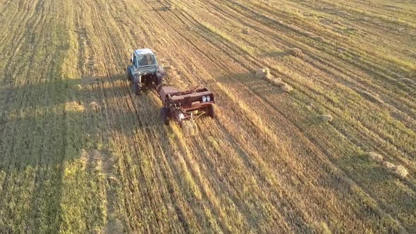 Drone Follows Tractor Baler Pushes Up Straw Bale on Field