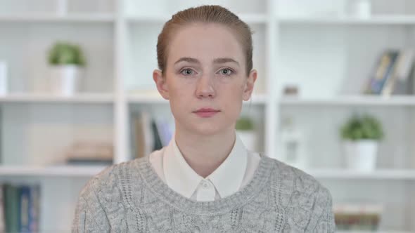 Portrait of Serious Young Woman Looking at Camera