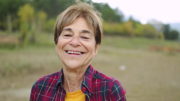 Happy Senior Woman Smiling on Camera Outdoor in the Woods  Real Elderly People Lifestyle