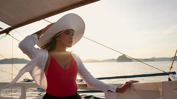 Woman Relaxing On Outrigger Boat In Sun Hat