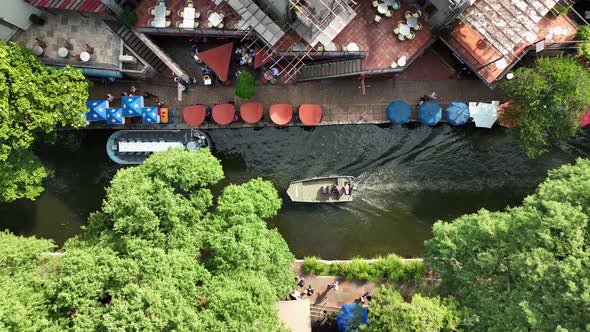 San Antonio TX famous River Walk. Aerial top down birds eye view of boats and barges passing by city
