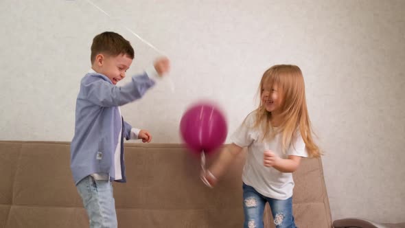 The Children are Jumping and Having Fun on the Couch with Balloons