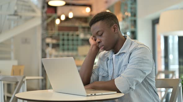 African Man with Laptop Sleeping in Cafe