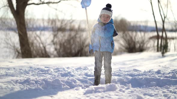 Little Boy Shoveling Snow at Winter