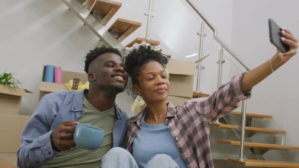 Video of happy african american couple taking selfie after moving into new house