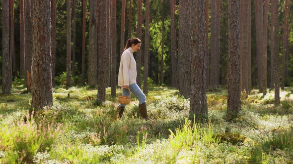 Woman with Mushrooms in Basket Walking in Forest