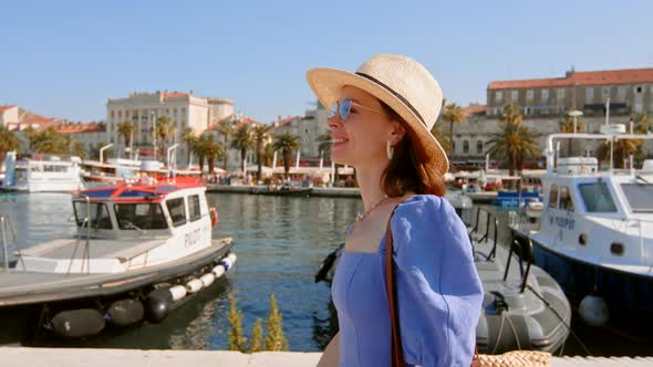 Attractive girl in a blue dress at the pier in the city. Split, Croatia