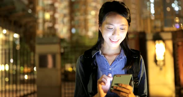 Young woman using smart phone at night 