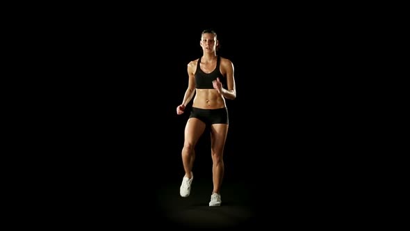 Young Athletic Woman Wearing Sporstwear is Exercising Isolated on Black