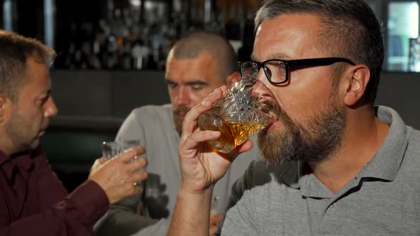 Bearded Mature Man Smiling To the Camera After Tasting Delicious Whiskey