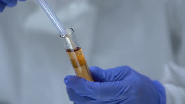 Chemist in Protective Uniform Taking Toxic Liquid Sample From Test-Tube, Danger