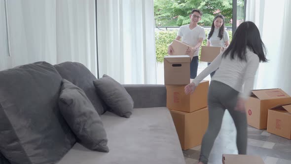 happy Asian family moving to new house with cardboard boxes and arrange the house.