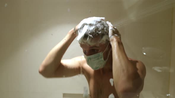 A Man Wearing a Face Mask Taking a Shower Washes His Head and Face with Loads of Soap Dancing