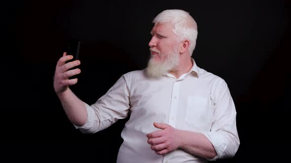 Funny Man with Albinism Using Phone and Taking Selfie on Black Background