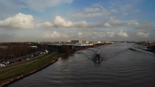 Fully loaded cargo barge sailing on the dutch river oude maas towards the next destination carrying