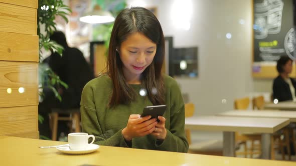 Woman Look at Cellphone at Indoor Cafe