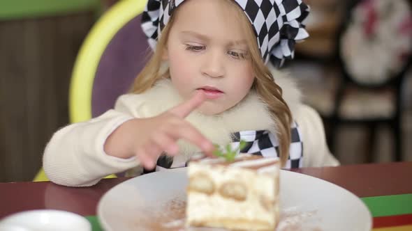 A charming little girl who eats a fresh sweet chocolate pie.