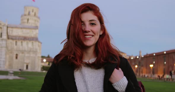 Young University Girl with Backpack in an Italian Square Smiles at the Camera