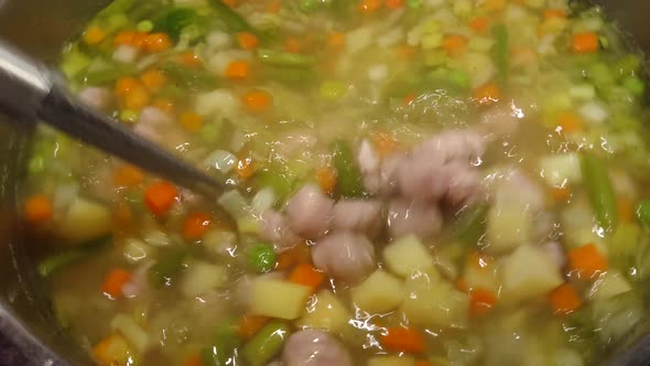 Cooking, mixing meatball to soup.