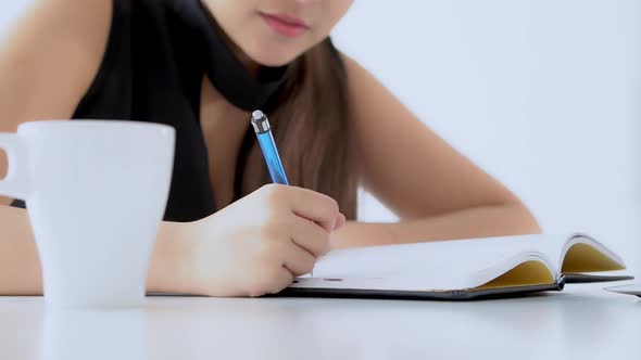 Closeup woman sitting in the living room study and learning writing notebook and diary.