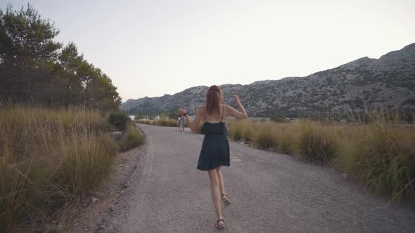 Beautiful Redhaired Woman Traveler Walks and Has a Good Time on the Rocky Island of Mallorca