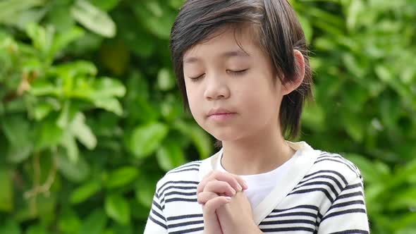 Cute Asian Boy Praying In The Park