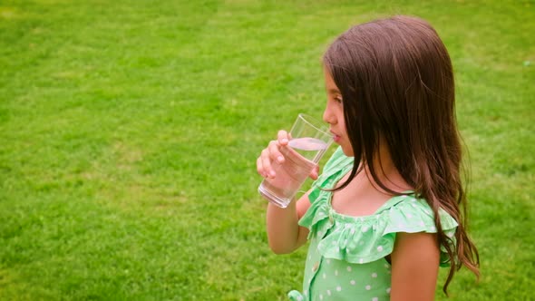 The Child Drinks Water From a Glass
