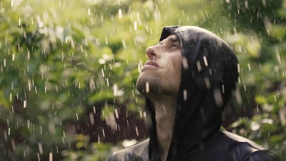 Happy Young Man Under Rain Looking Up