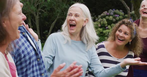 Animation of happy diverse female and male senior friends talking and having fun together in garden