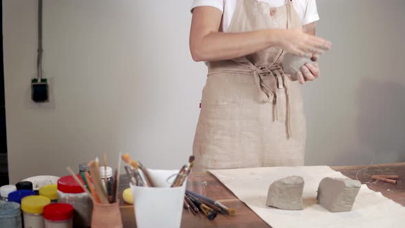 Woman Sculptor Is Shaping Round Blanks From Gray Clay in Workshop