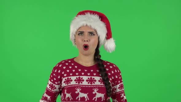 Portrait of Sweety Girl in Santa Claus Hat Is Frustrated Saying Oh My God and Being Shocked. Green