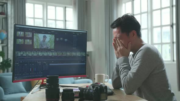 Asian Video Editor Man Being Tired While Using Desktop Computer For Editing Video At Home