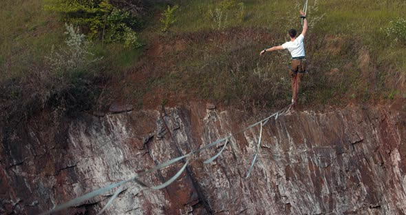 Danger Extreme Sports a Man Is Walking on the Tightrope Over a Massive Pit