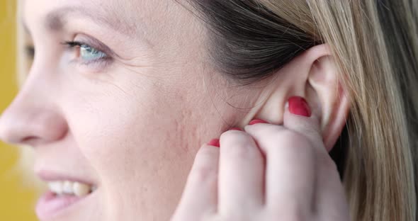 Young Smiling Woman Inserting White Wireless Headphones Into Her Ear Closeup  Movie