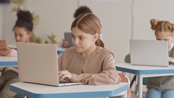 Schoolgirl Studying on Laptop in Class
