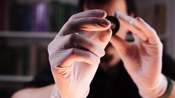 Pawnshop Owner Examines Golden Ring with Diamond with Magnifying Glass