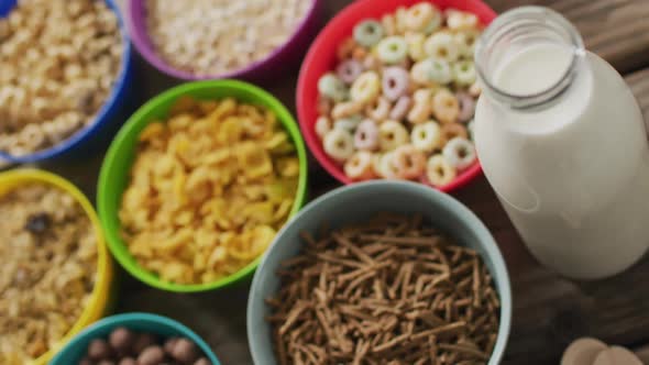 Video of cereals in colorful bowls on wooden kitchen worktop