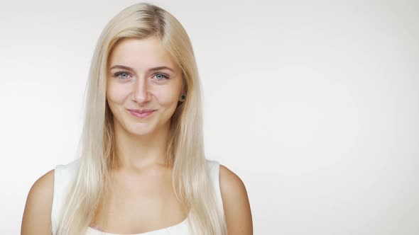 Beautiful Caucasian Female Blondie Smiling at Camera Flirting with Tricky Look Over White Background