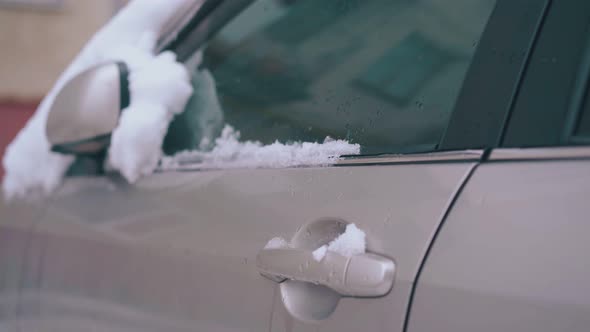 Snow Lies on Car with Folded Rearview Mirror and Front Door