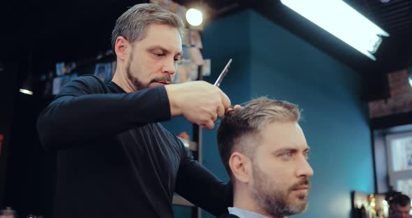 Brutal Barber Scissors Man's Hair in a Salon