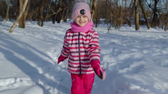 Smiling Child Kid Running Having Fun Dancing Fooling Around on Snowy Road in Winter Park Forest