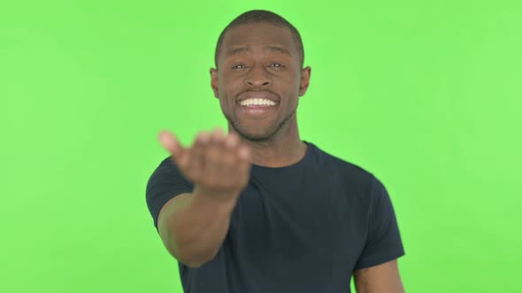 Inviting Young African Man Pointing at Camera on Green Background