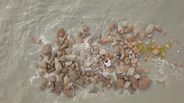 Top down view fisherman sit on rock