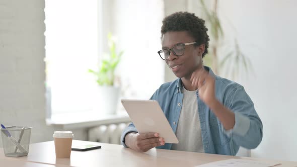 Online Video Chat on Tablet By Young African Man in Office