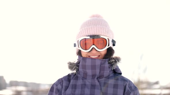 Woman Snowboarder Put on Goggles on Ski Resort Before Skiing