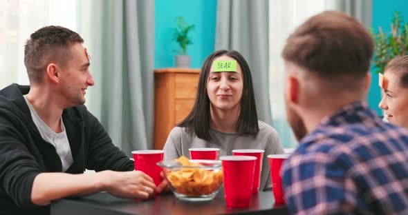 In the Living Room Diverse Group of Fun Loving Friends Playing Who Am I Game