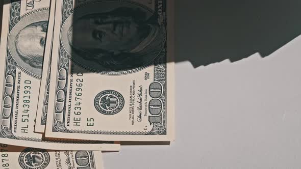 Male Hands Counting Old Hundred Dollar Banknotes on a White Table