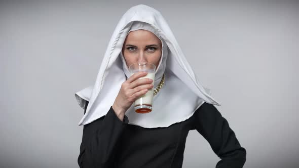 Smiling Woman in Nun Costume Drinking White Milk Licking Lips Smiling Looking at Camera